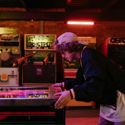 Man in Black Jacket and White Pants Standing in Front of Counter