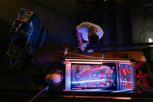 Man in White T-shirt Playing Arcade Game